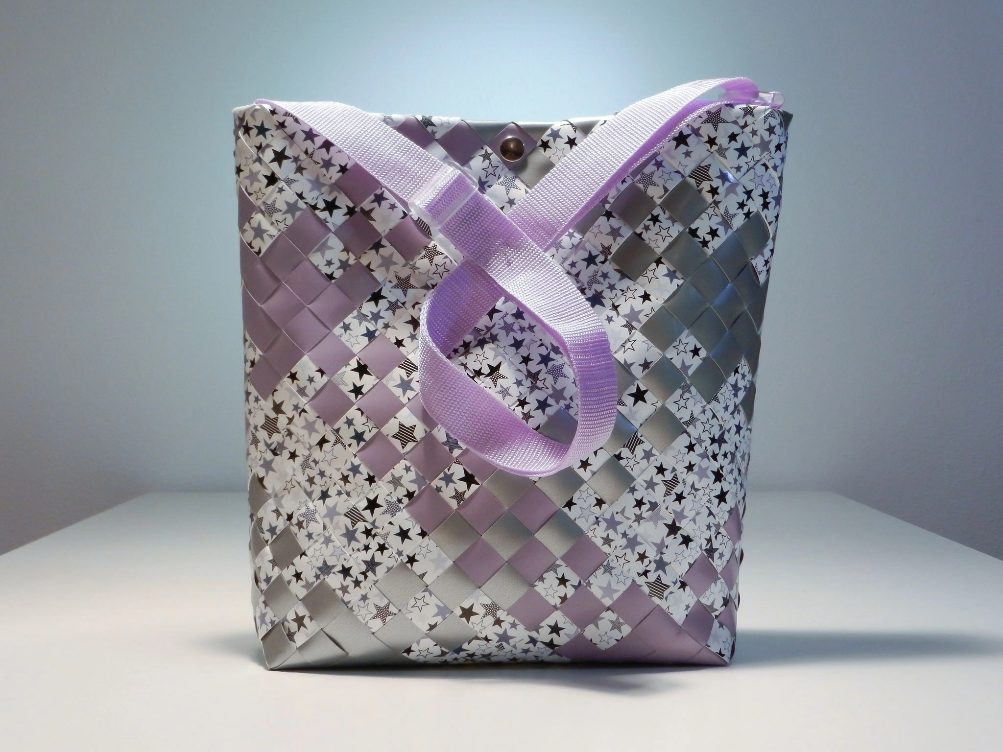 Flechttasche mit Sternenmuster, silber-lilafarbenen Streifen und hellvioletten Trägern