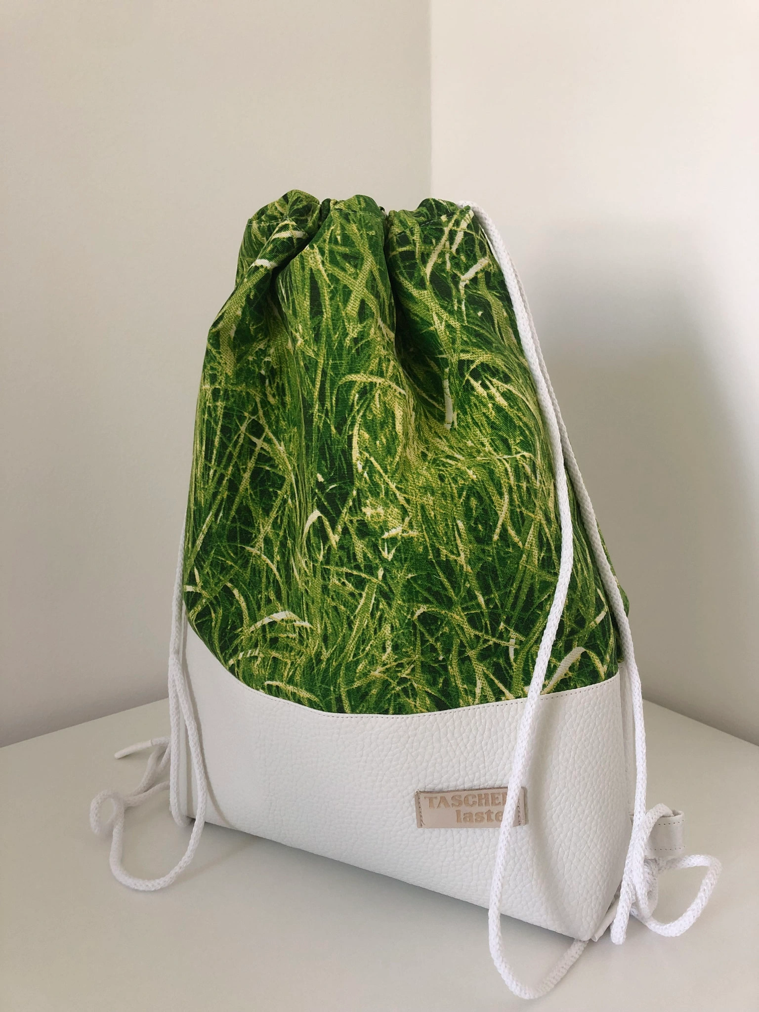 Grün-weißer Athena-Zugbeutel mit Gras-Motiv und hellem Boden