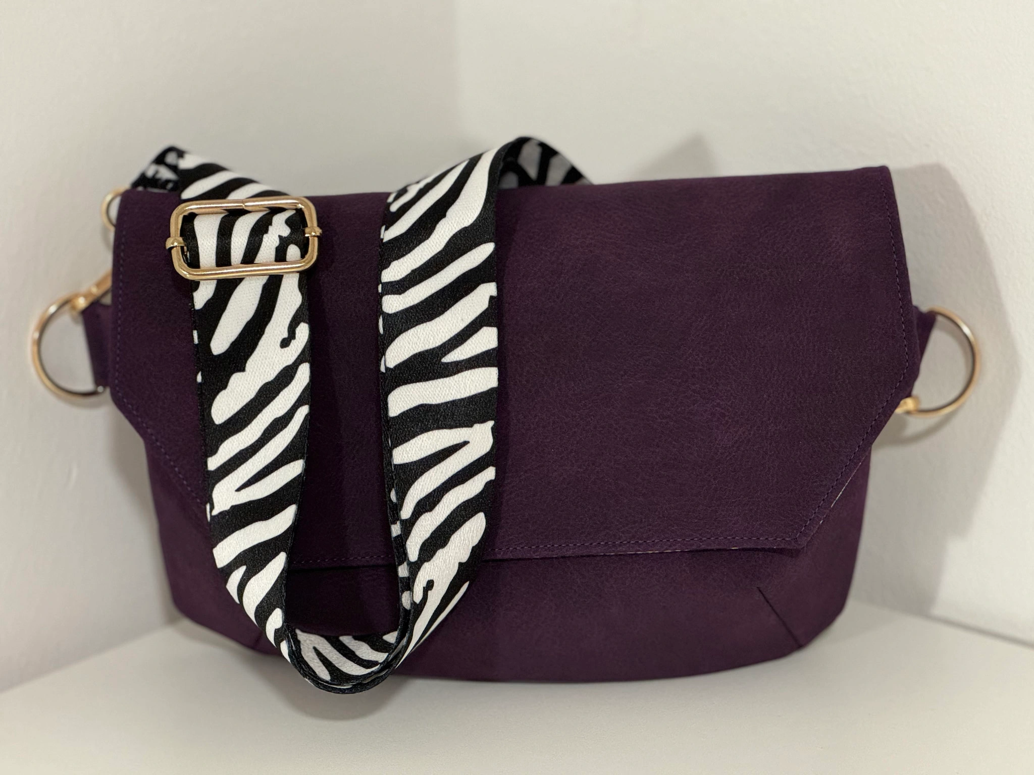 Dunkelviolette Nachtschwärmerin mit schwarz-weißem Zebra-Schultergurt